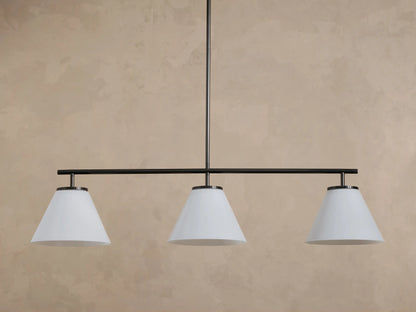Front view of a three-light linear pendant chandelier with white conical shades and a dark bronze finish.