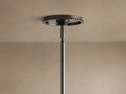 A three-light pendant fixture with a dark metal frame and three conical white glass shades, hanging against a textured wall.