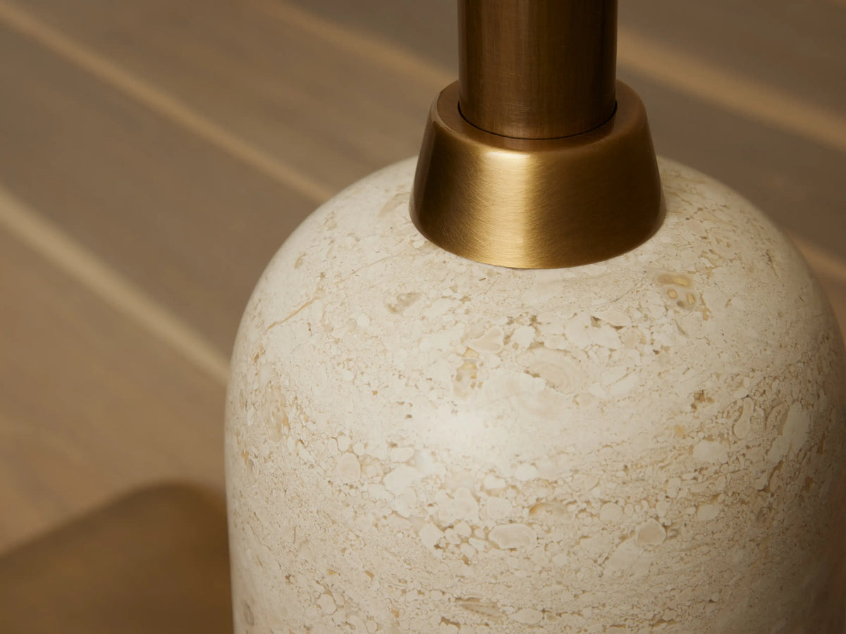 Close-up of Christie Floor Lamp's cream natural stone base with mottled patterns, connecting to a brass-finished stem.