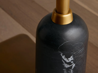 Close-up of Christie Floor Lamp's black marble base with white veining and brass-finished steel stem against wood floor.