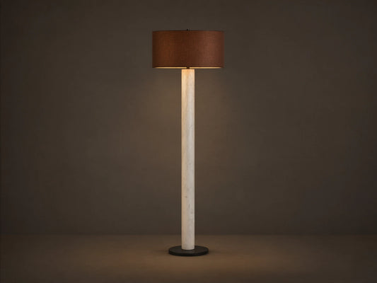 Brixton Floor Lamp with a slender white marble column, dark round base, and a brown fabric drum shade on a wooden floor.