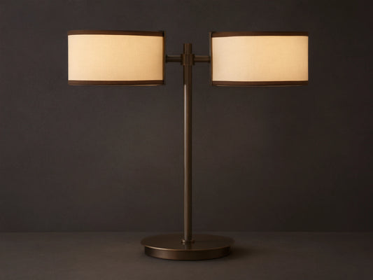 Daphne 2-Light Table Lamp with bronze-finished steel base and two cream shades with brown trim on a wooden surface.