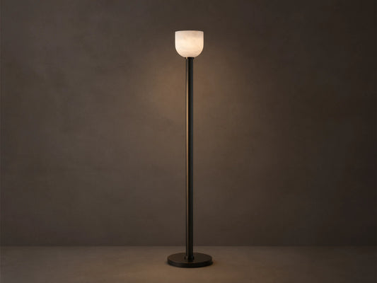 Ansley Floor Lamp: tall, dark steel pole and round base with an illuminated natural alabaster stone shade on a wooden floor.