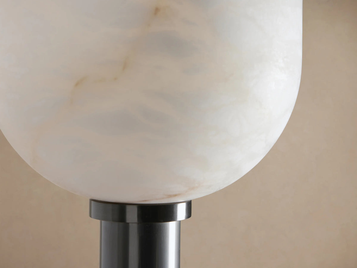 Ansley Floor Lamp: Slim dark steel pole and round base with a white alabaster bowl-shaped shade, on wood floor, tan wall.