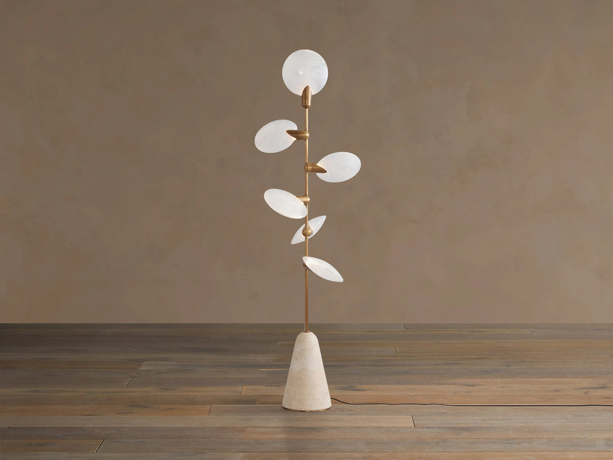 Lyla Floor Lamp: conical travertine base, golden stem with six glowing leaf-shaped white glass diffusers spirally.