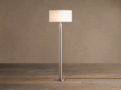 Linden Floor Lamp in Pewter: Tall, slender, metallic pewter finish pole and round base, with a white cylindrical linen shade.