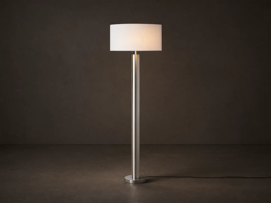 Linden Floor Lamp in Pewter: Tall, slender, metallic pewter finish pole and round base, with a white cylindrical linen shade.