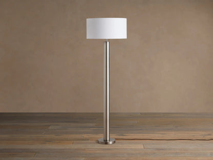 Linden Floor Lamp in Pewter: Tall, slender, metallic pewter finish pole and round base, with a white cylindrical linen shade.