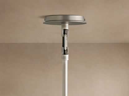 Close-up of a Linden Pendant, viewed from below, showing its light linen shade, warm interior glow, and dark metal accent.