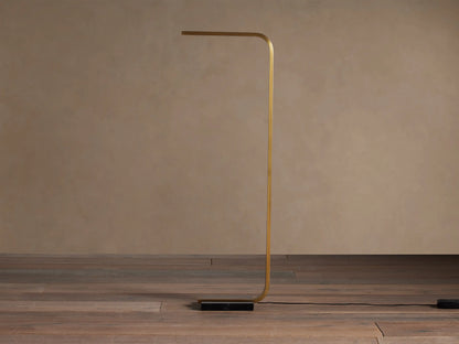 Modern golden brass Karson Task Floor Lamp with a bent rectangular frame, horizontal light bar, and black marble base.