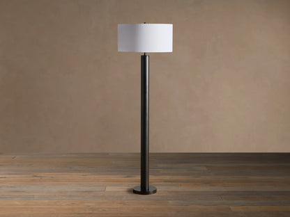 Linden Floor Lamp: tall, dark bronze-finished pole with a round base, topped by an illuminated white cylindrical linen shade.
