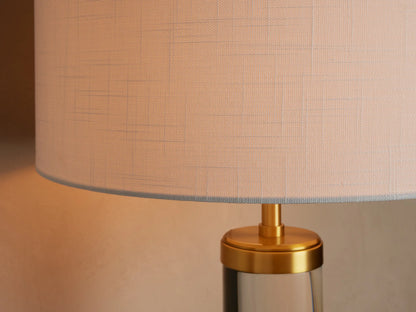 Close-up of the Linden Crystal Table Lamp, highlighting its natural linen shade, brass-finished metal, and clear crystal column.