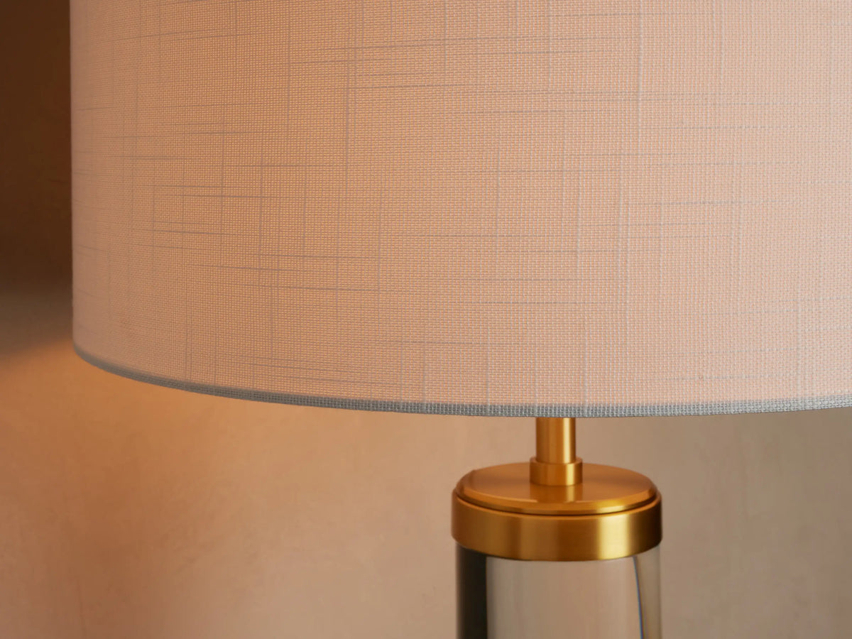 Front view of the Linden Crystal Table Lamp with clear crystal column, brass accents, and an illuminated linen shade.