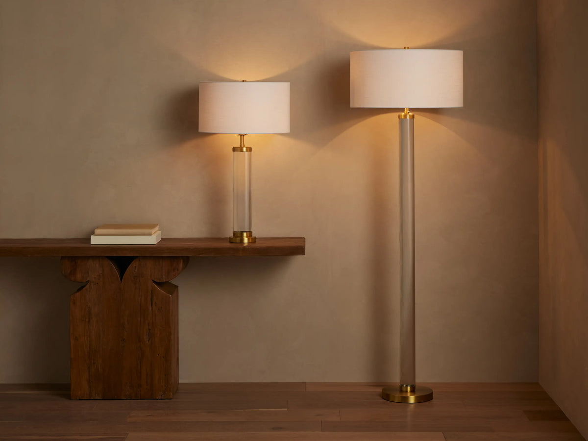 Linden Crystal Floor Lamp. Close-up of brass stem, clear crystal base, white linen shade glowing with warm light, pull chain.