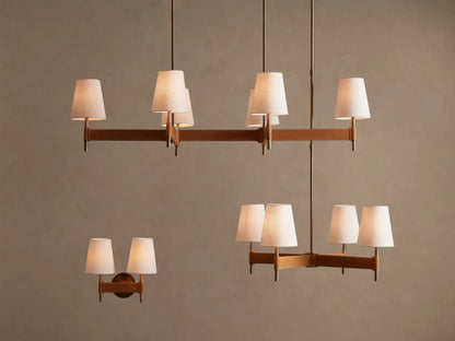 Close-up of Hastings Linear Chandelier's oblong antique brass canopy attached to a beige ceiling, with two vertical brass rods extending down.