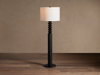 Black Lathe Floor Lamp with a cylindrical black oak base, stacked carved black wood details, and an off-white linen drum shade.