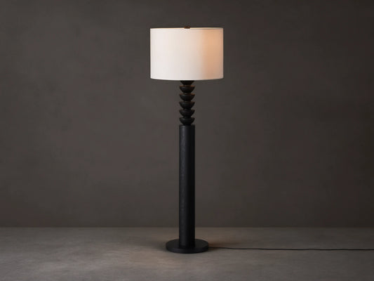Black Lathe Floor Lamp with a cylindrical black oak base, stacked carved black wood details, and an off-white linen drum shade.
