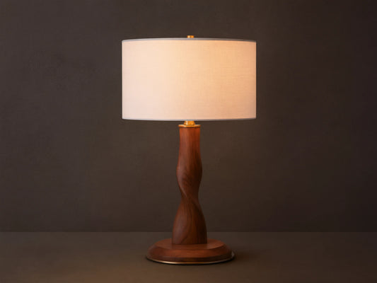 Jonas Table Lamp: Light flax linen shade, dark twisted oak wood stem & base, brass accents, on a rustic wood surface.