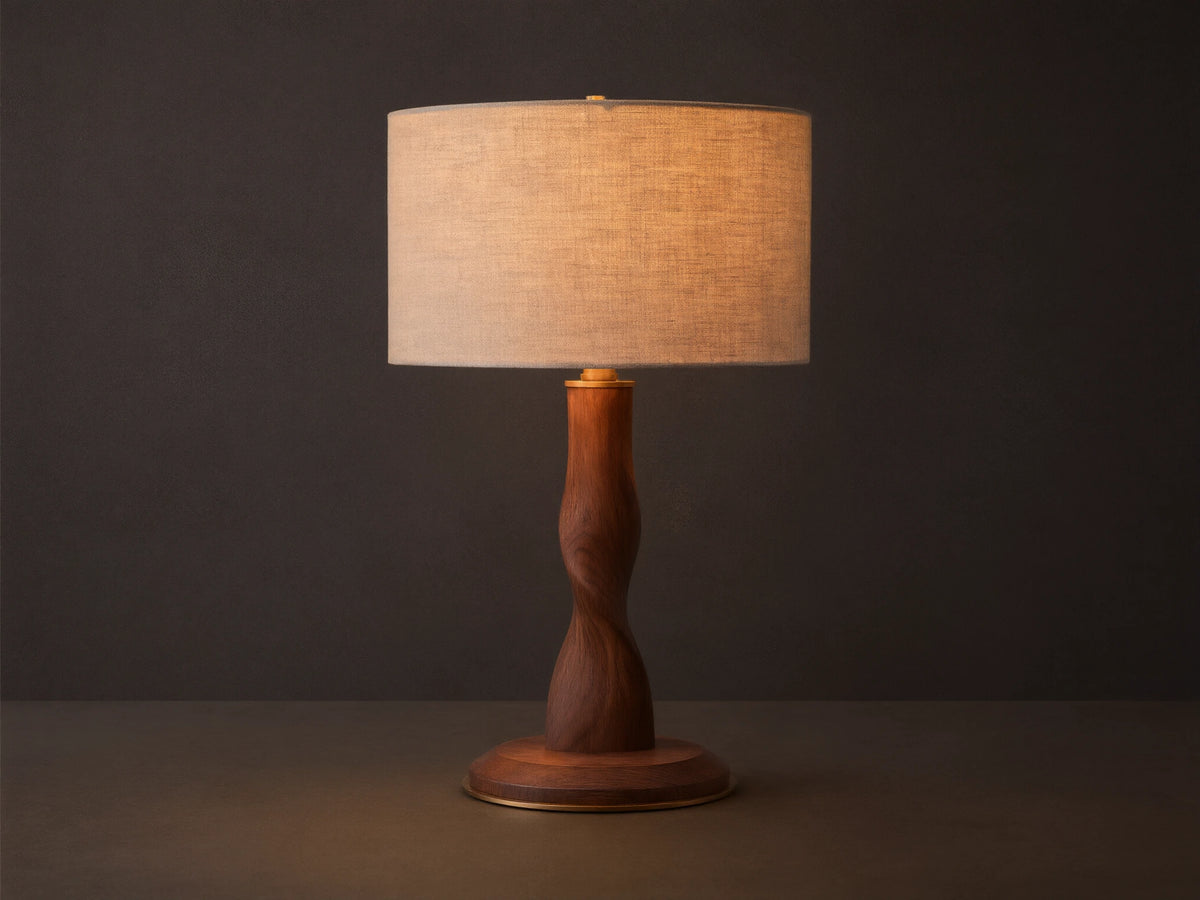 Jonas Table Lamp with a light flax linen shade, twisted dark oak wood base, and brass accents, sitting on a rustic wooden table.