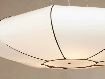 Nuvola Chandelier: Oval white milk glass pendant light with dark bronze-finished steel frame, hanging against a light brown wall.