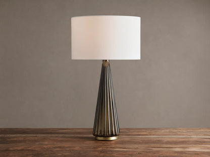 Elisabetta Table Lamp: upright, white linen shade, smoky fluted glass base, brass accent, sitting on a wooden table.