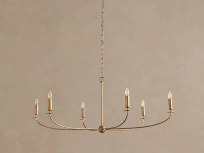 Arnett Chandelier: An antiqued gold 6-light chandelier hangs centrally, featuring curved arms with clear candle-style bulbs.