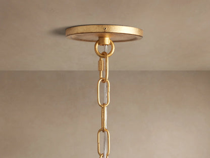 Arnett Chandelier's antiqued gold round canopy, chain, and clear cord, seen mounted on a light-colored ceiling.