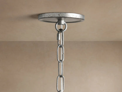 Close-up of Arnett Round Chandelier with antiqued leaf finish, showing three illuminated candle-style bulbs and curved metal arms.