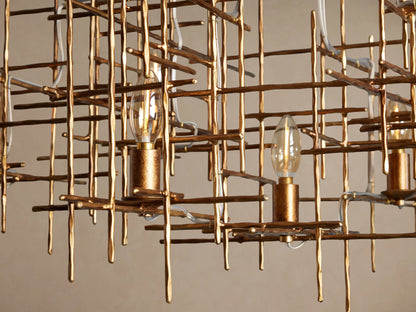 Fritz Chandelier: gold hand-hammered iron with an abstract grid design, featuring 7 exposed clear candle-style bulbs.