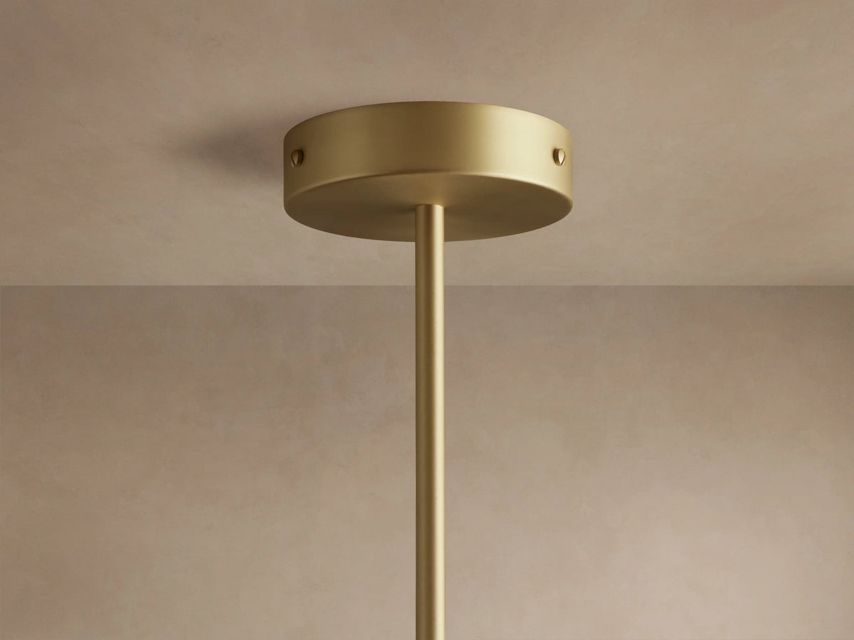 Ramsey Round Chandelier with two illuminated white fabric shades, matte black tops, and satin brass arms on a dark wall.