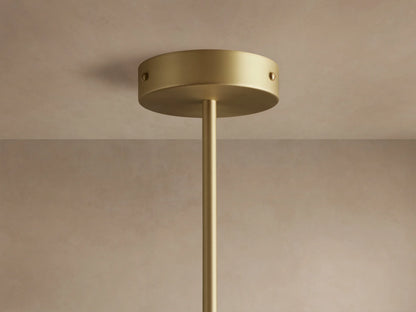 Ramsey Round Chandelier with two illuminated white fabric shades, matte black tops, and satin brass arms on a dark wall.