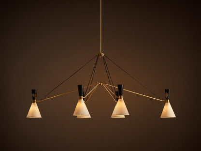 Ramsey Linear Chandelier with a satin brass frame, matte black accents, and six glowing white conical fabric shades.