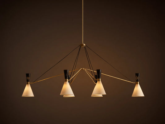 Ramsey Linear Chandelier with a satin brass frame, matte black accents, and six glowing white conical fabric shades.