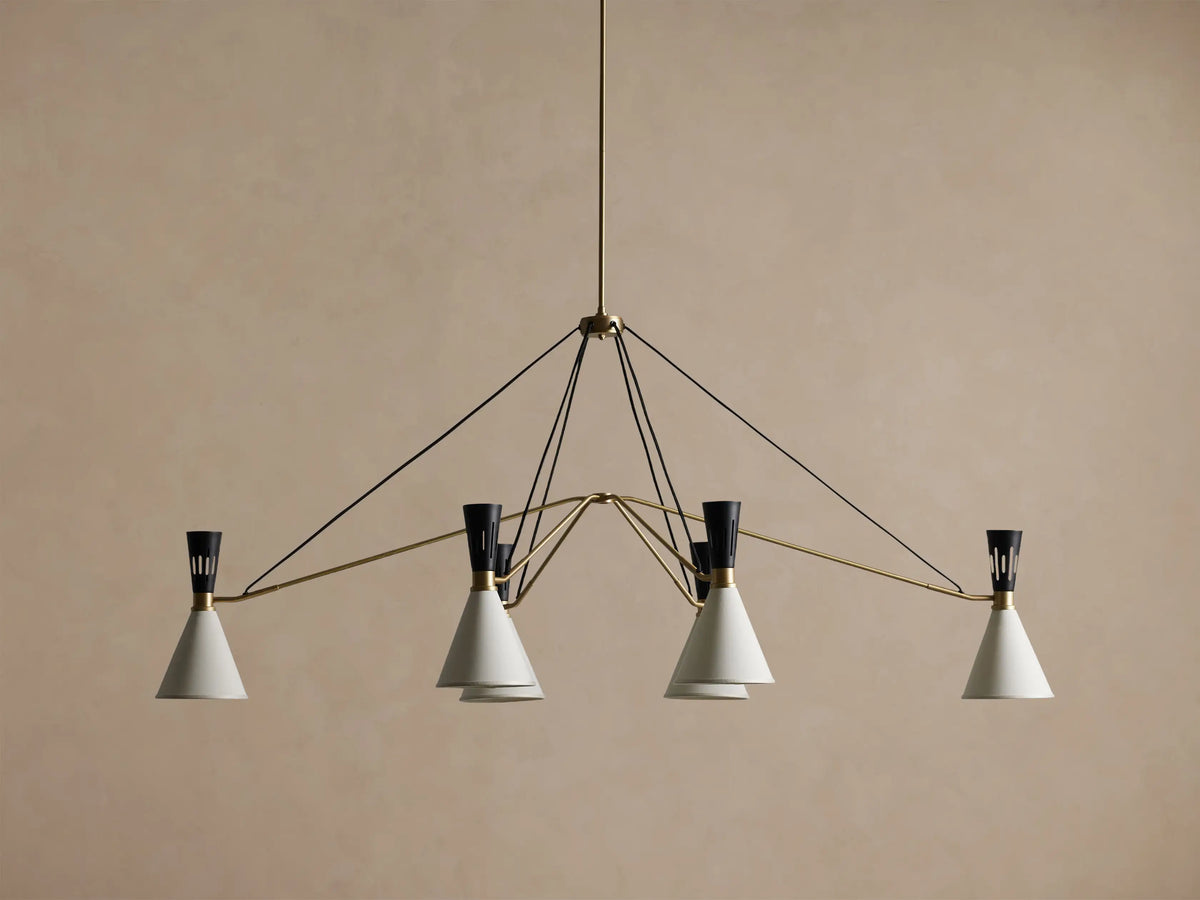 Ramsey Linear Chandelier with a satin brass frame, matte black accents, and six glowing white conical fabric shades.