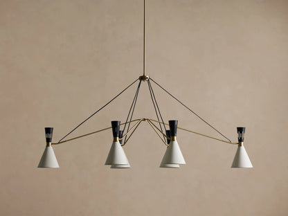 Ramsey Linear Chandelier with a satin brass frame, matte black accents, and six glowing white conical fabric shades.