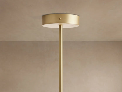Close-up of Ramsey Linear Chandelier with brass frame, black metal accents, and three glowing white fabric cone shades.