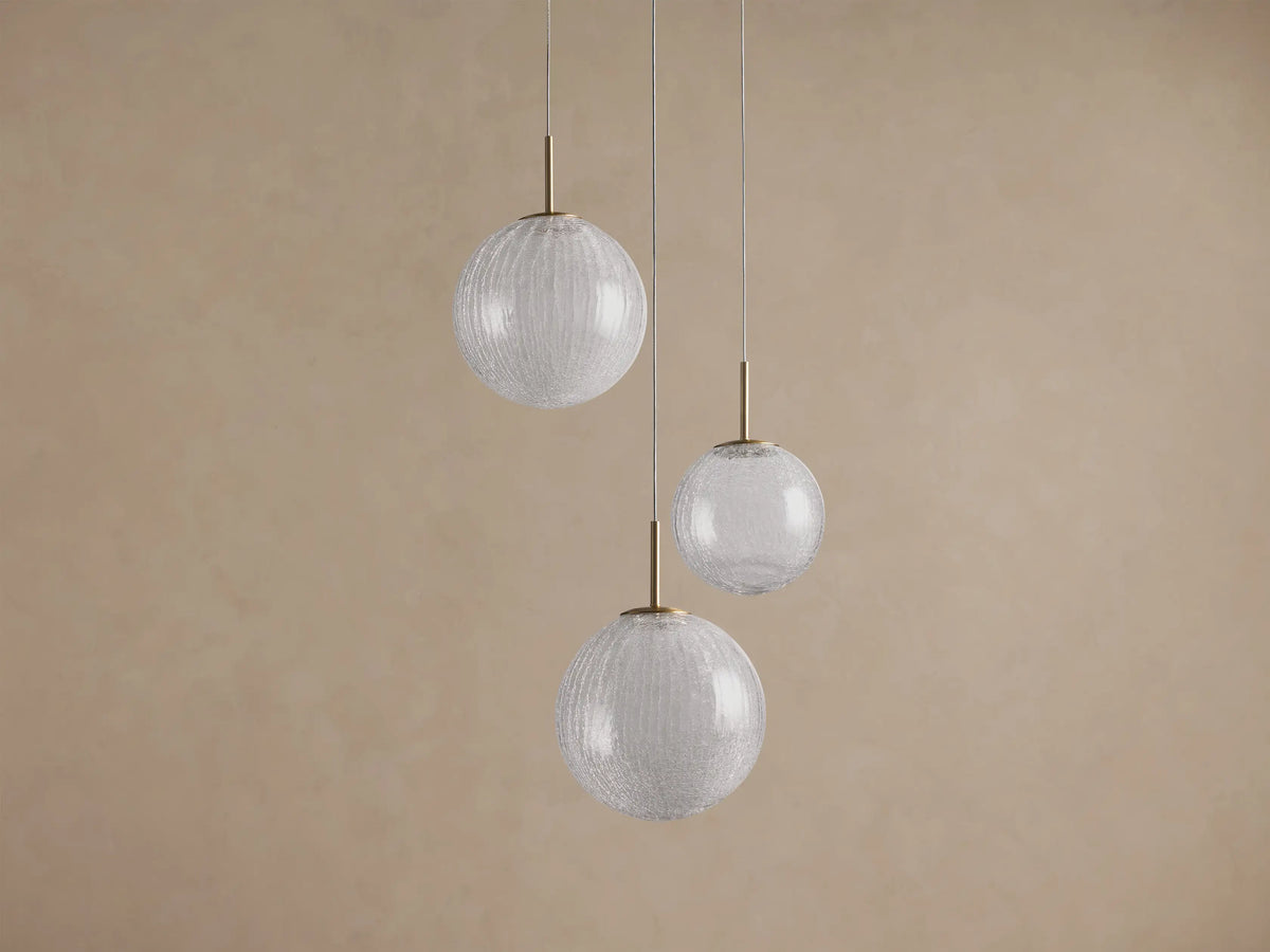 Casen Round Chandelier with three clear crackle glass globes of varying sizes, suspended by thin wires and brass accents.