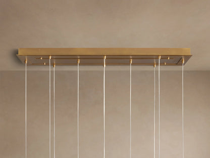 Casen Linear Chandelier: Close-up of glowing white opal glass globes with satin brass fittings.