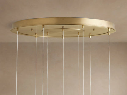 Casen Round Chandelier. Close-up of the satin brass circular ceiling canopy with numerous thin silver suspension wires.