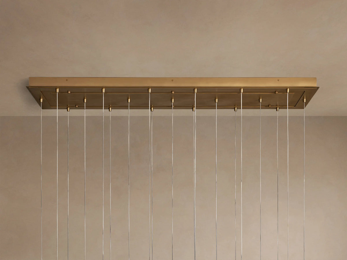 Casen Linear Chandelier: close-up of multiple illuminated white opal glass globes suspended by satin brass fixtures.