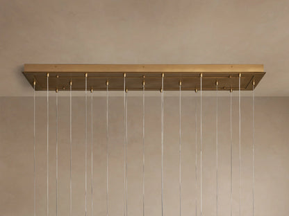 Casen Linear Chandelier: close-up of multiple illuminated white opal glass globes suspended by satin brass fixtures.