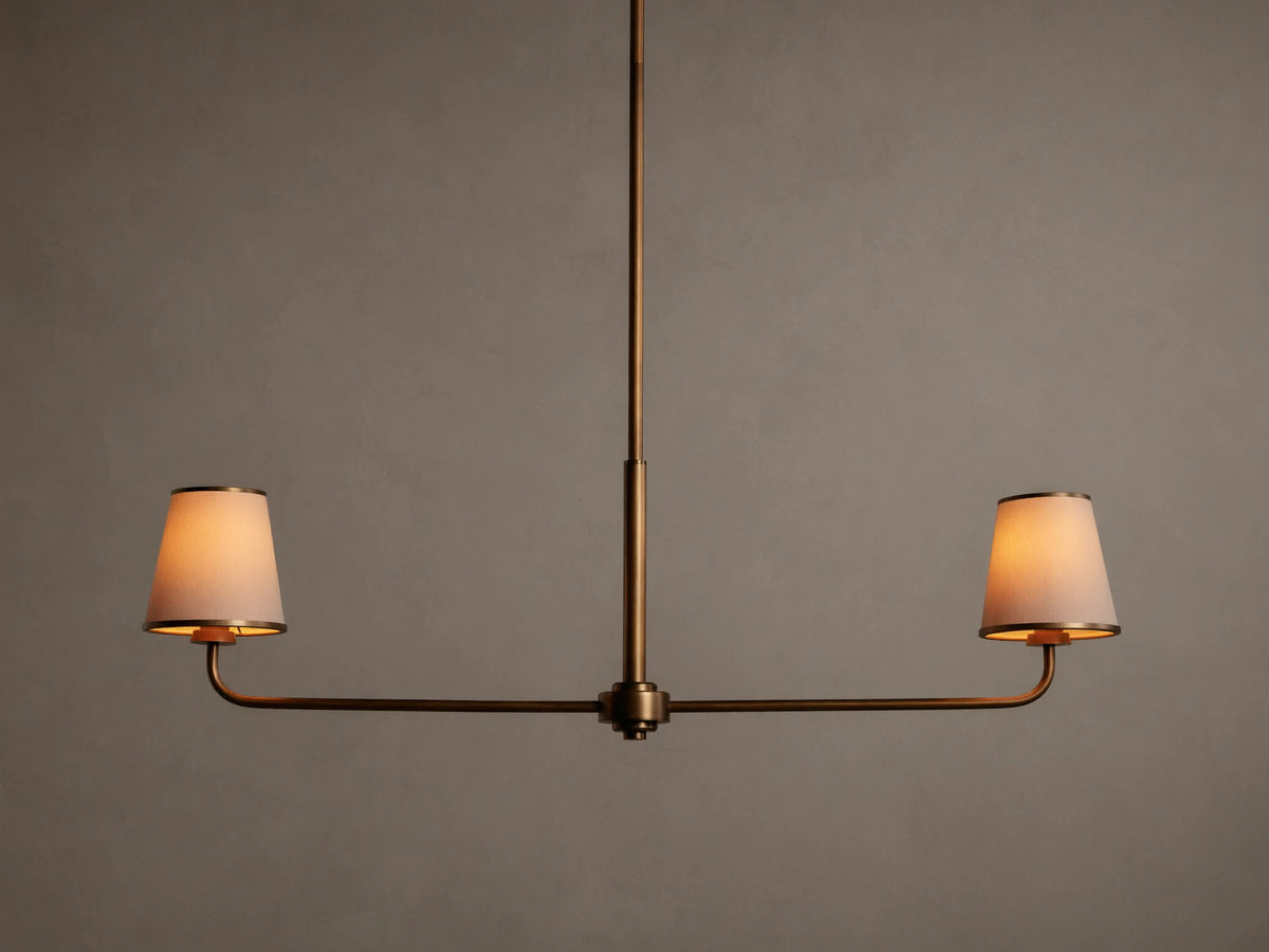 Adria 2-Light Chandelier: Bronze-finished frame with two glowing, tapered off-white fabric shades on a horizontal bar.