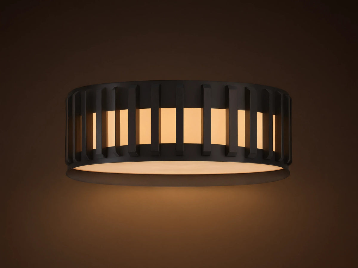 Gabbia Outdoor Flush Mount, matte black round light with vertical slatted shade & glowing milk glass, mounted on a ceiling.