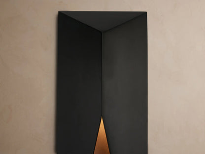 Davian Outdoor Sconce, a sleek black rectangular light with geometric angled front, mounted vertically on a light beige wall.