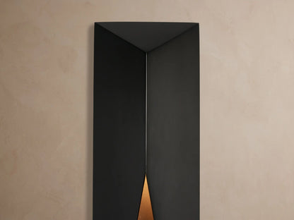 Davian Outdoor Sconce, dark bronze finish, geometric vertical form with angled cutouts, mounted on a light beige wall.