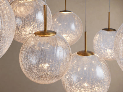 A close-up of the Casen Round Chandelier featuring multiple illuminated crackle glass globes with satin brass accents.