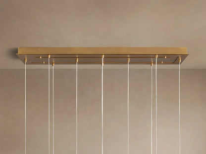 Close-up of Casen Linear Chandelier with illuminated crackle glass globes and satin brass accents, casting a warm glow.