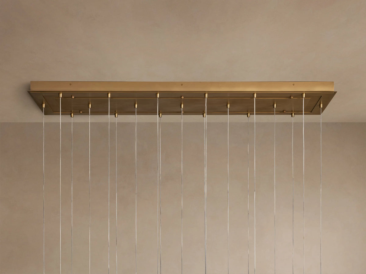 Close-up of Casen Linear Chandelier with multiple glowing crackle glass globes and satin brass accents against a soft background.