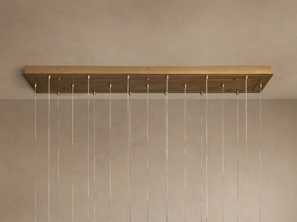 Close-up of Casen Linear Chandelier with multiple glowing crackle glass globes and satin brass accents against a soft background.