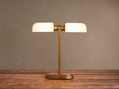 Zayd Table Lamp: modern brass base and stem, supporting two glowing horizontal opal glass shades, on a dark wooden table.